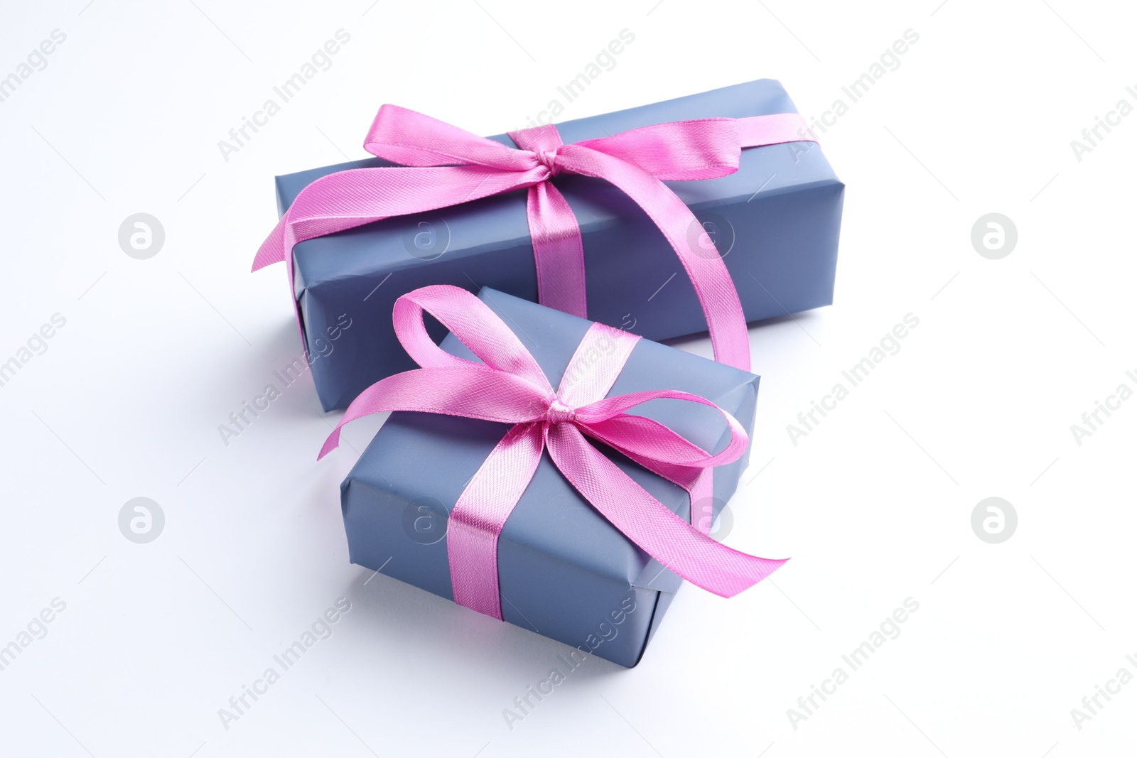 Photo of Beautiful gift boxes with pink bows isolated on white