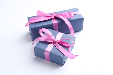 Photo of Beautiful gift boxes with pink bows isolated on white