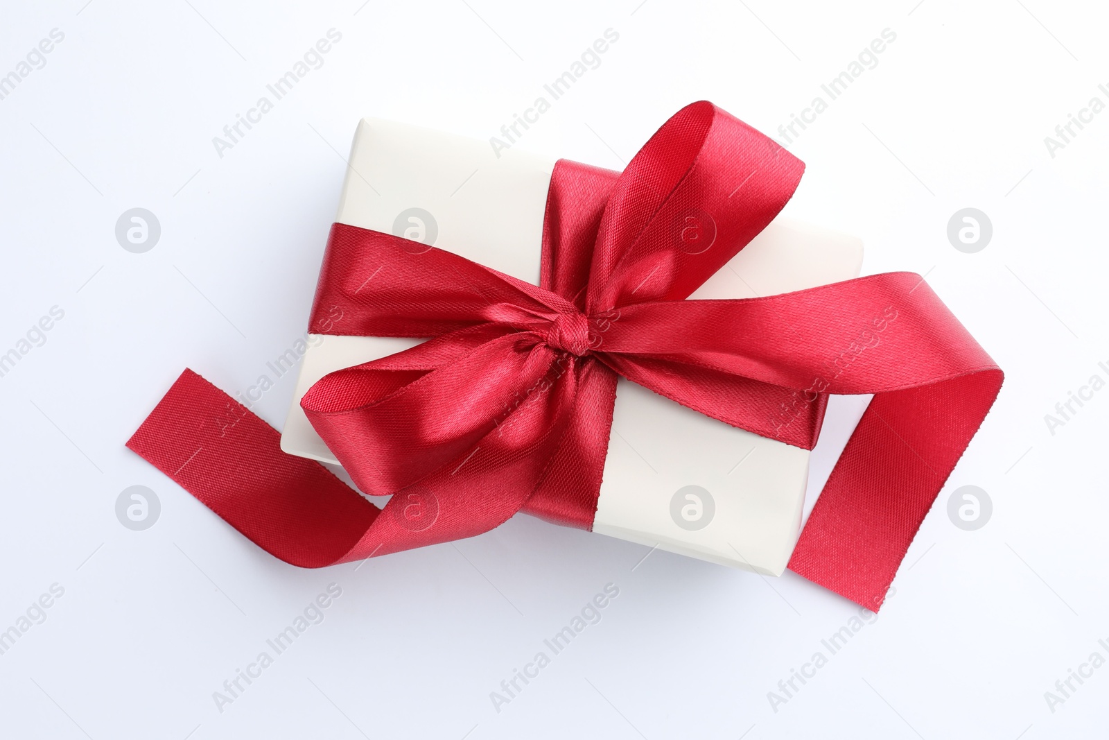 Photo of Beautiful gift box with red bow isolated on white, top view