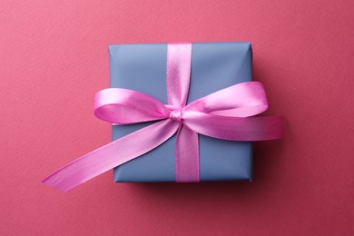 Photo of Beautiful gift box with bow on pink background, top view