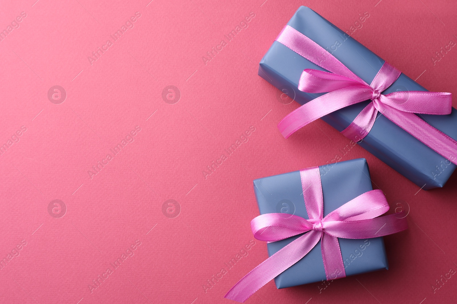 Photo of Beautiful gift boxes with bows on pink background, top view. Space for text