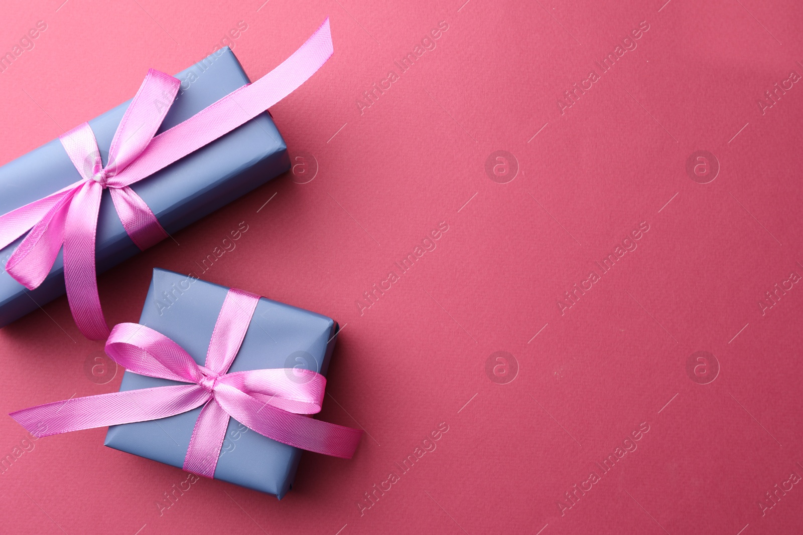 Photo of Beautiful gift boxes with bows on pink background, top view. Space for text