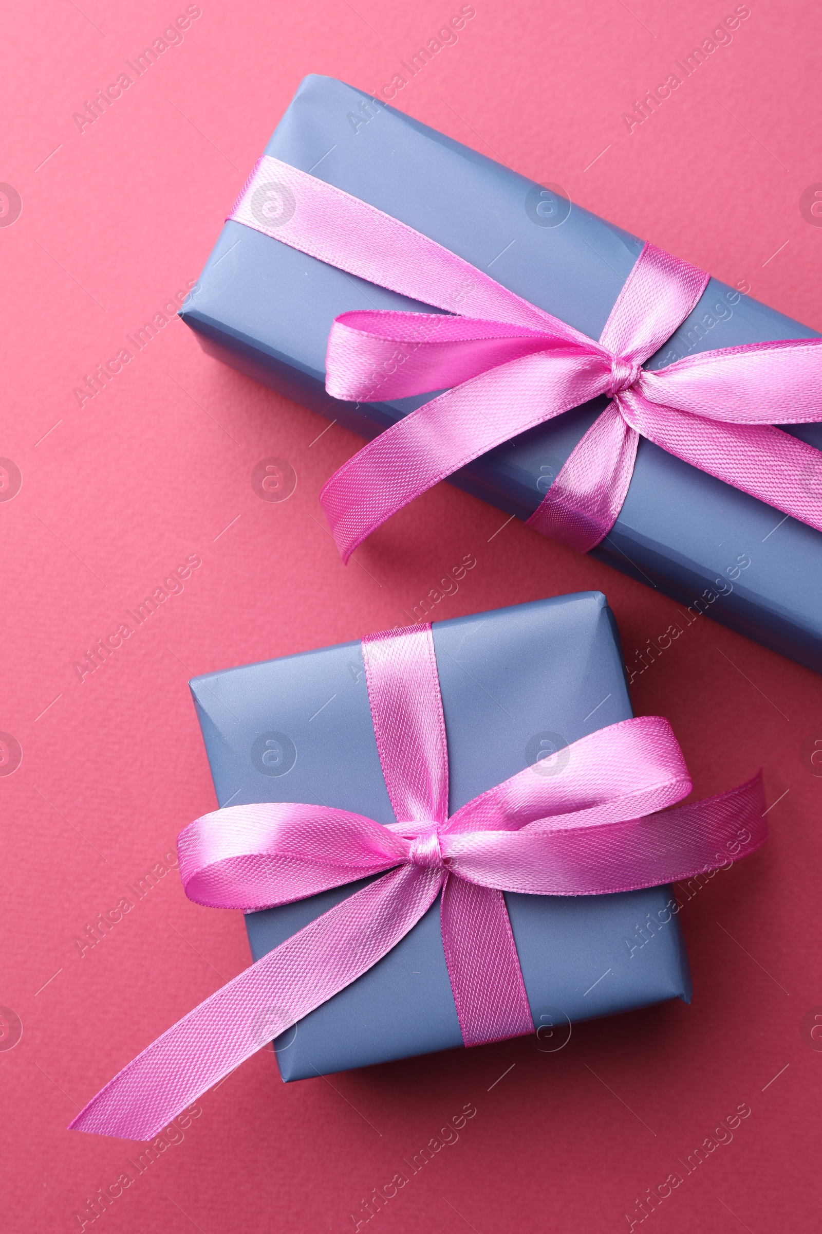 Photo of Beautiful gift boxes with bows on pink background, top view