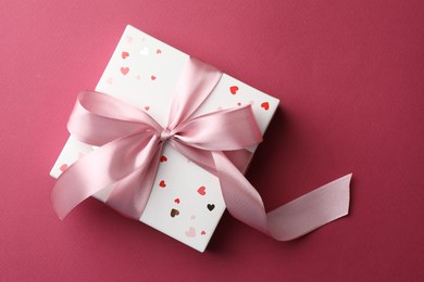 Photo of Beautiful gift box with bow on pink background, top view