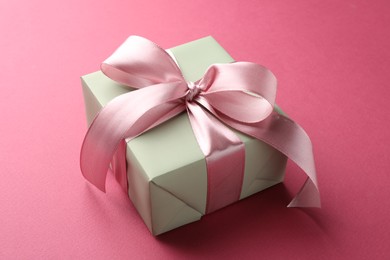 Photo of Beautiful gift box with bow on pink background, closeup