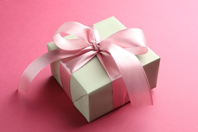 Photo of Beautiful gift box with bow on pink background, closeup