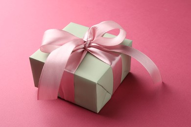 Photo of Beautiful gift box with bow on pink background, closeup