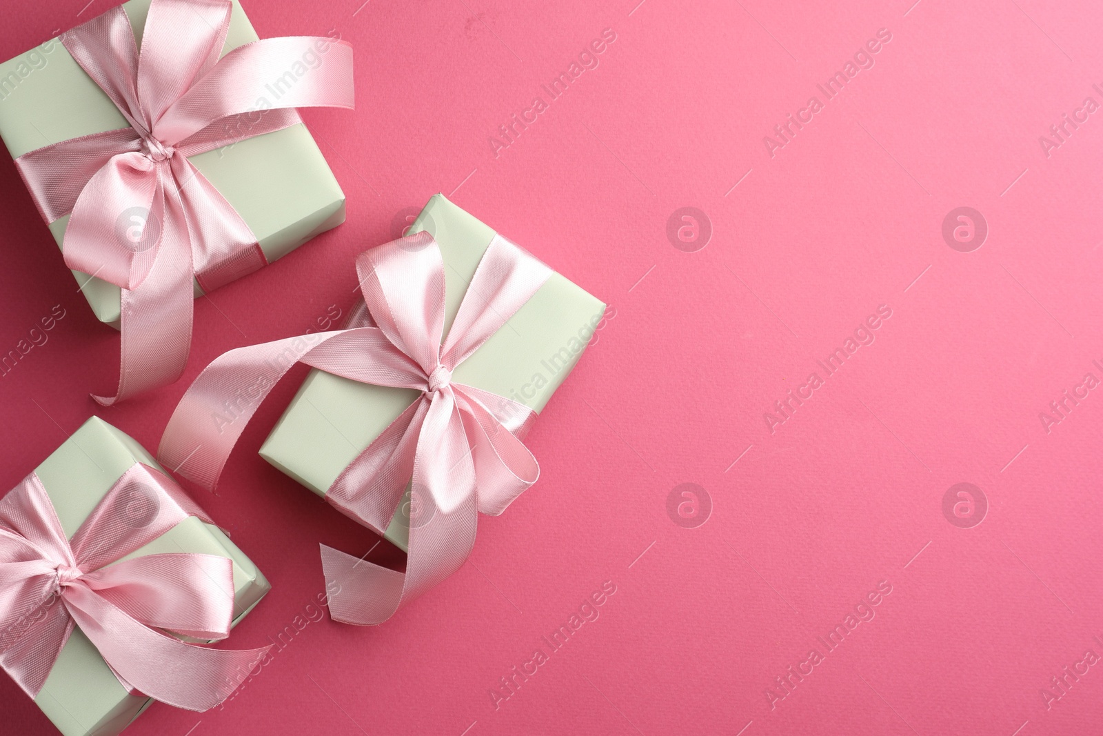 Photo of Beautiful gift boxes with bows on pink background, flat lay. Space for text