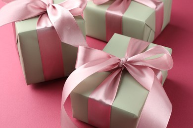 Beautiful gift boxes with bows on pink background, closeup