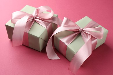 Photo of Beautiful gift boxes with bows on pink background