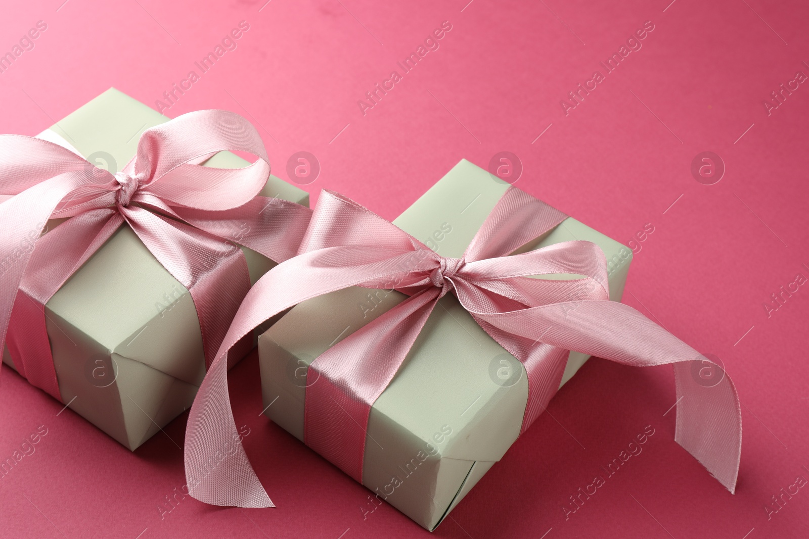 Photo of Beautiful gift boxes with bows on pink background