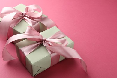 Photo of Beautiful gift boxes with bows on pink background, space for text