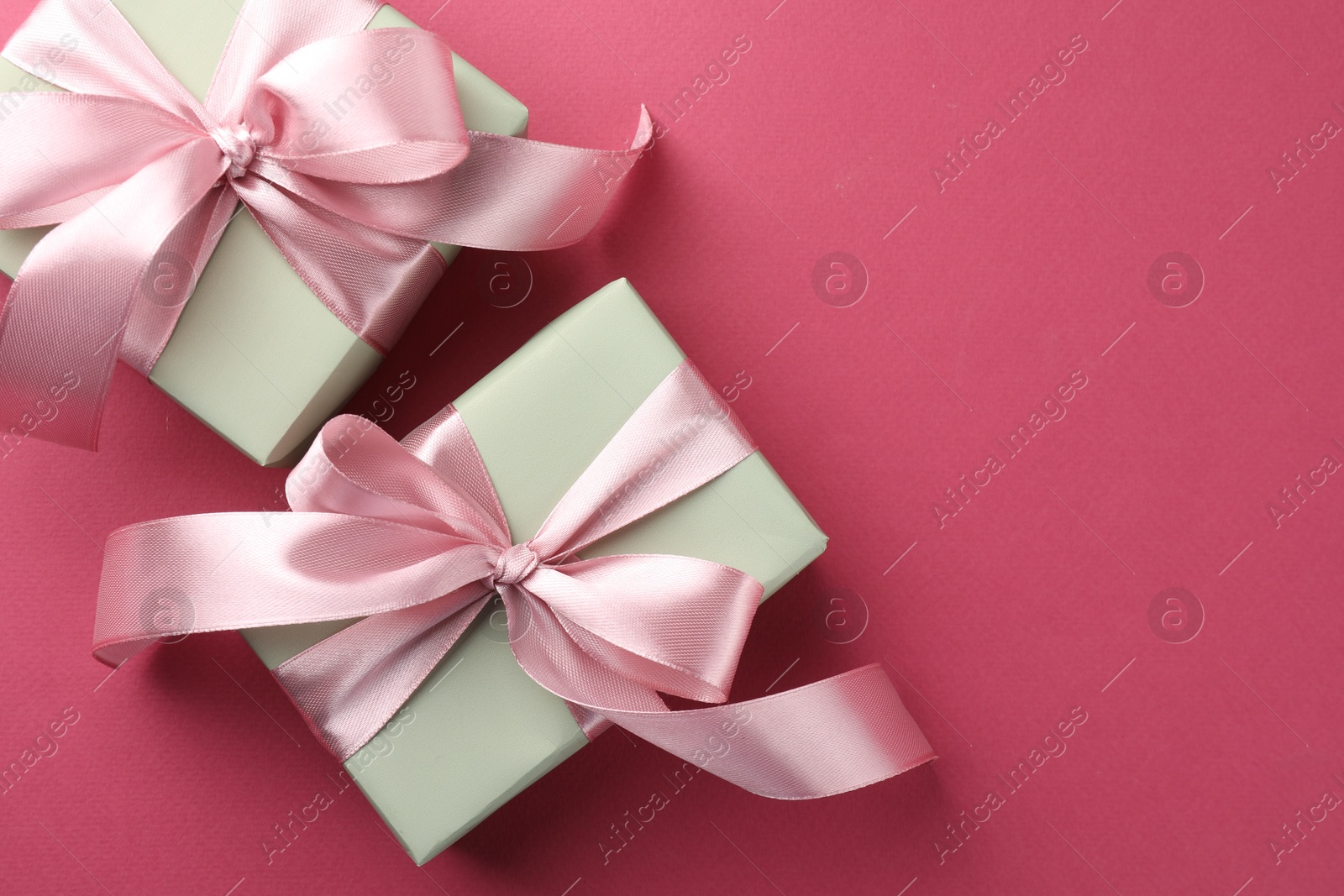 Photo of Beautiful gift boxes with bows on pink background, top view. Space for text