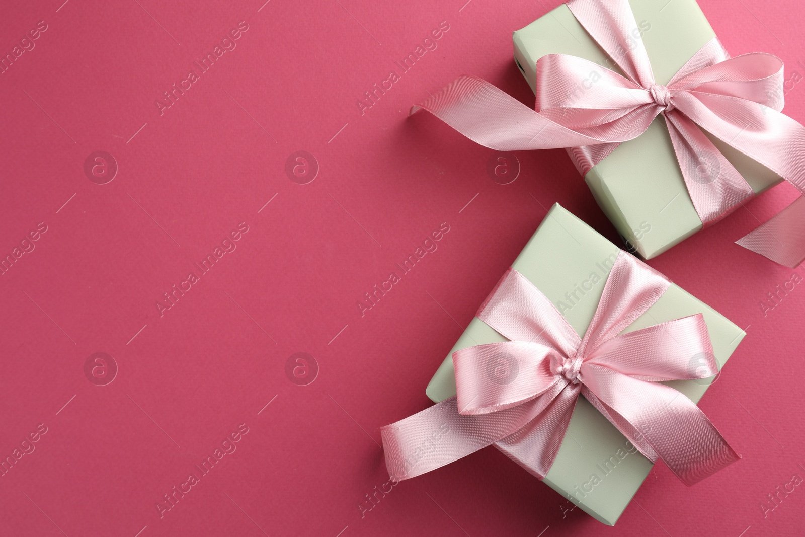 Photo of Beautiful gift boxes with bows on pink background, top view. Space for text