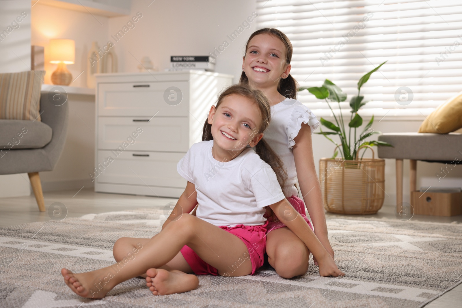 Photo of Portrait of cute little sisters at home