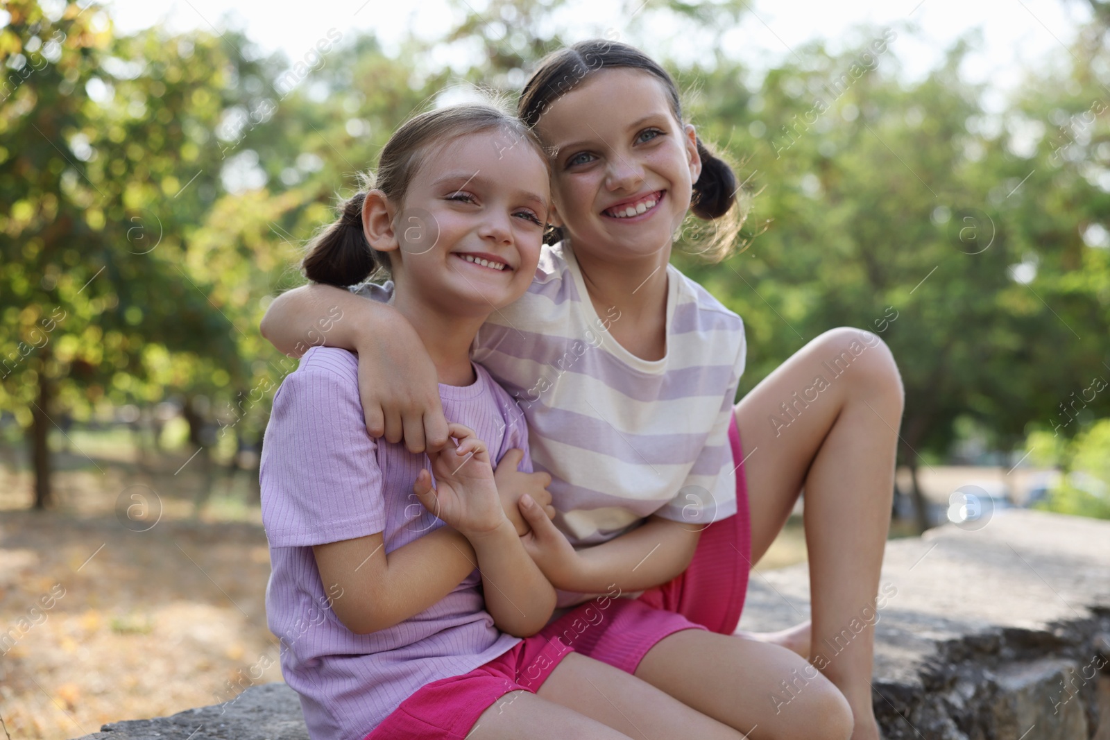 Photo of Portrait of cute little sisters in park