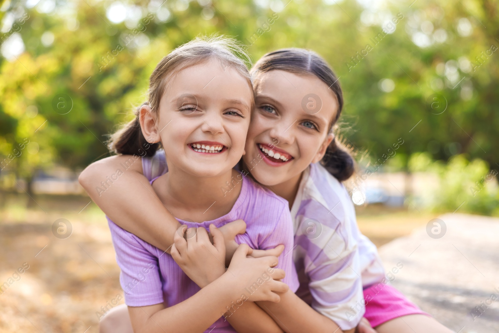 Photo of Portrait of cute little sisters in park