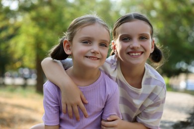 Photo of Portrait of cute little sisters in park