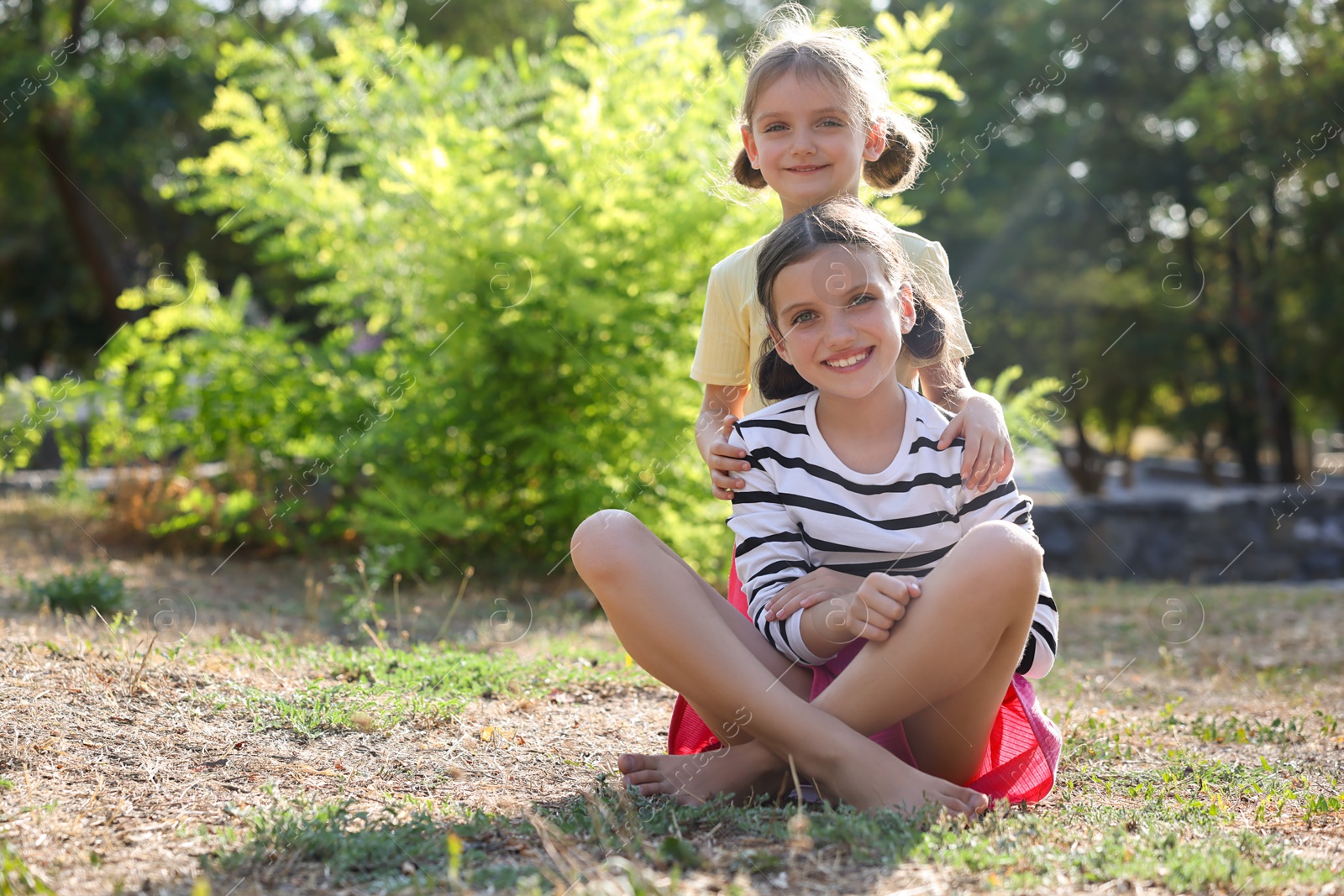 Photo of Portrait of cute little sisters in park