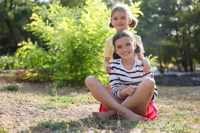 Portrait of cute little sisters in park