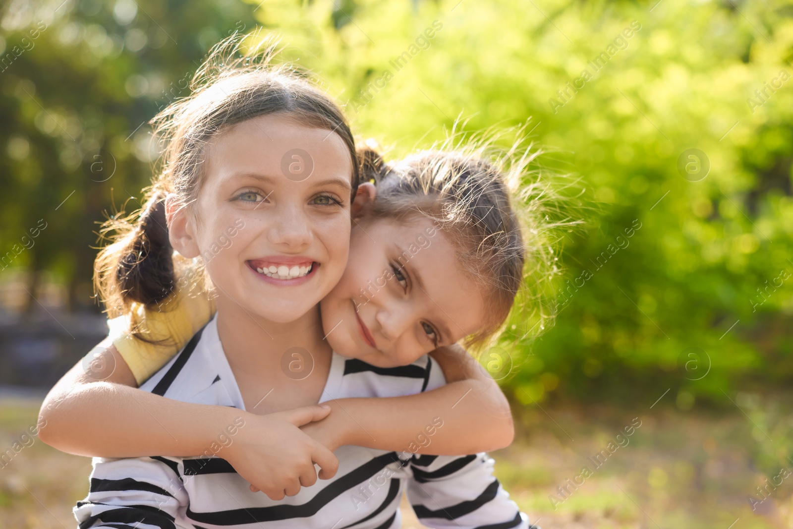 Photo of Portrait of cute little sisters in park