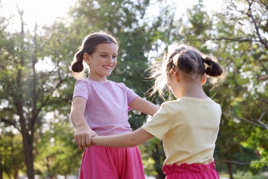 Cute little sisters spending time together in park