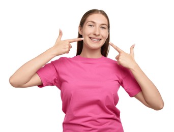 Photo of Smiling girl pointing at her braces on white background