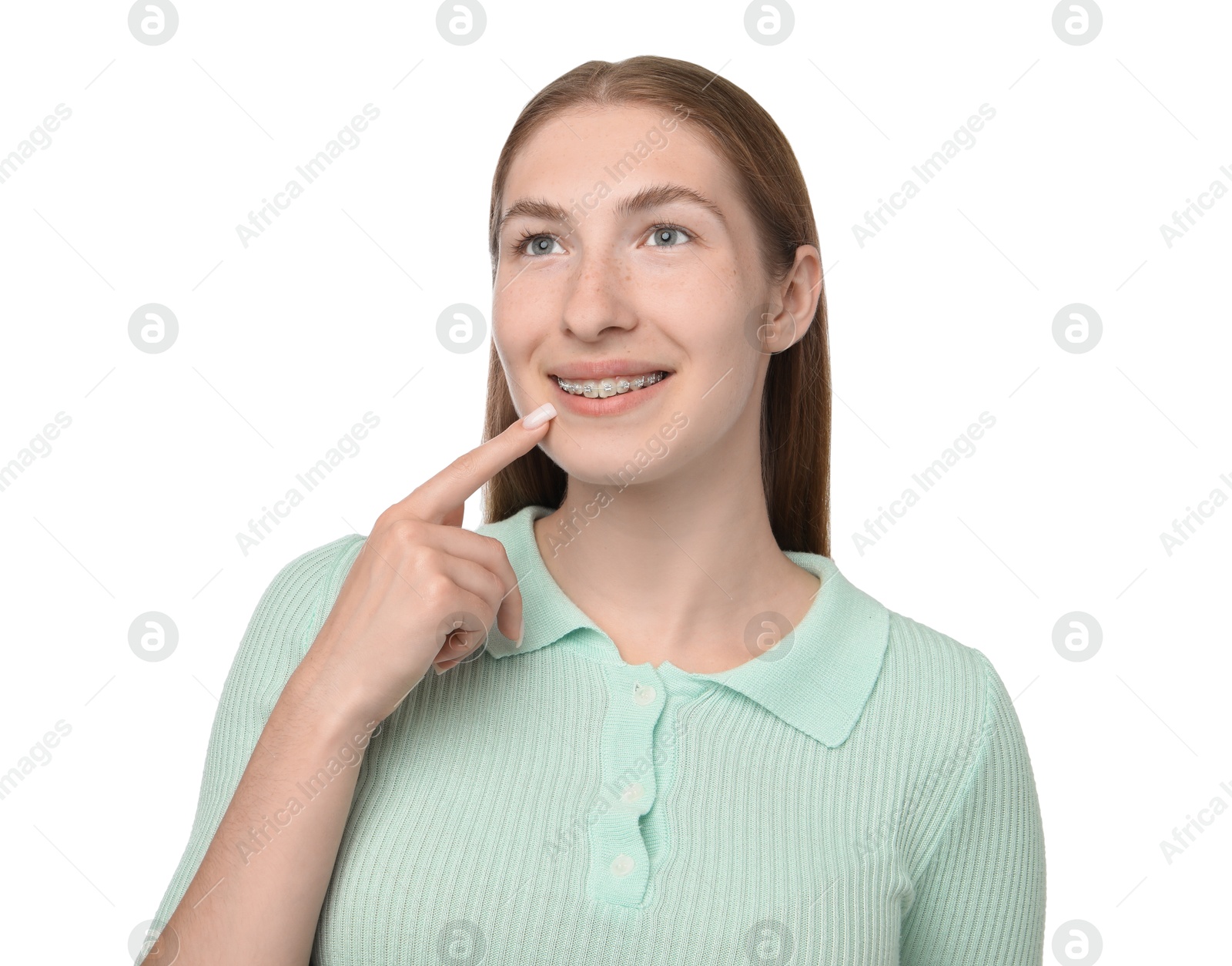 Photo of Smiling girl pointing at her braces on white background