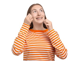 Photo of Smiling girl with braces cleaning teeth with dental floss on white background