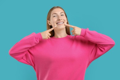 Photo of Girl pointing at her braces on light blue background