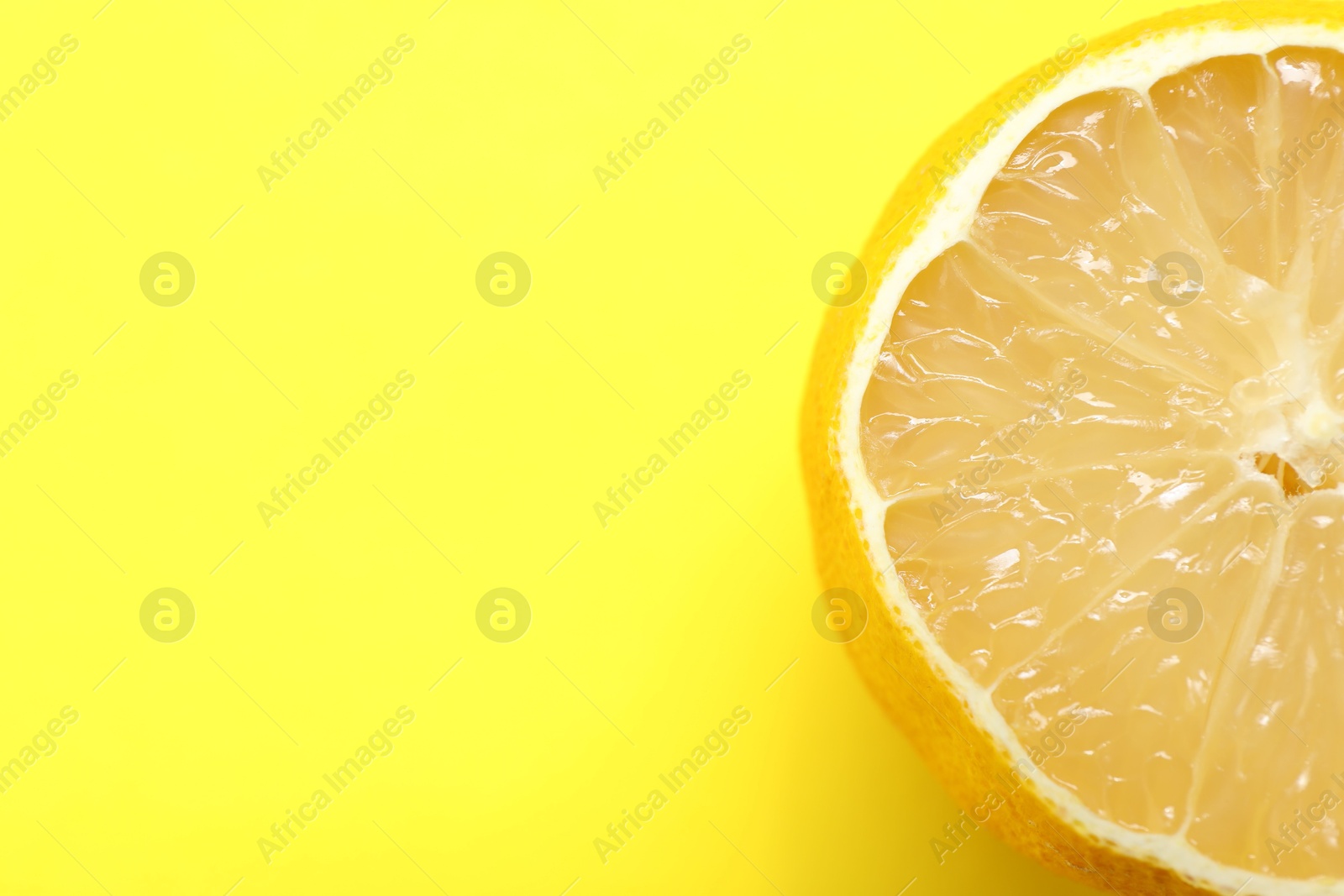 Photo of Fresh lemon half on yellow background, top view. Space for text