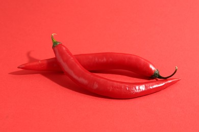 Fresh ripe chili peppers on red background