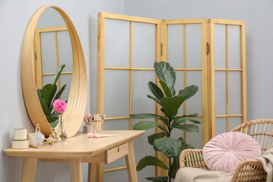 Photo of Mirror, dressing table, houseplant, folding screen and chair indoors. Interior design