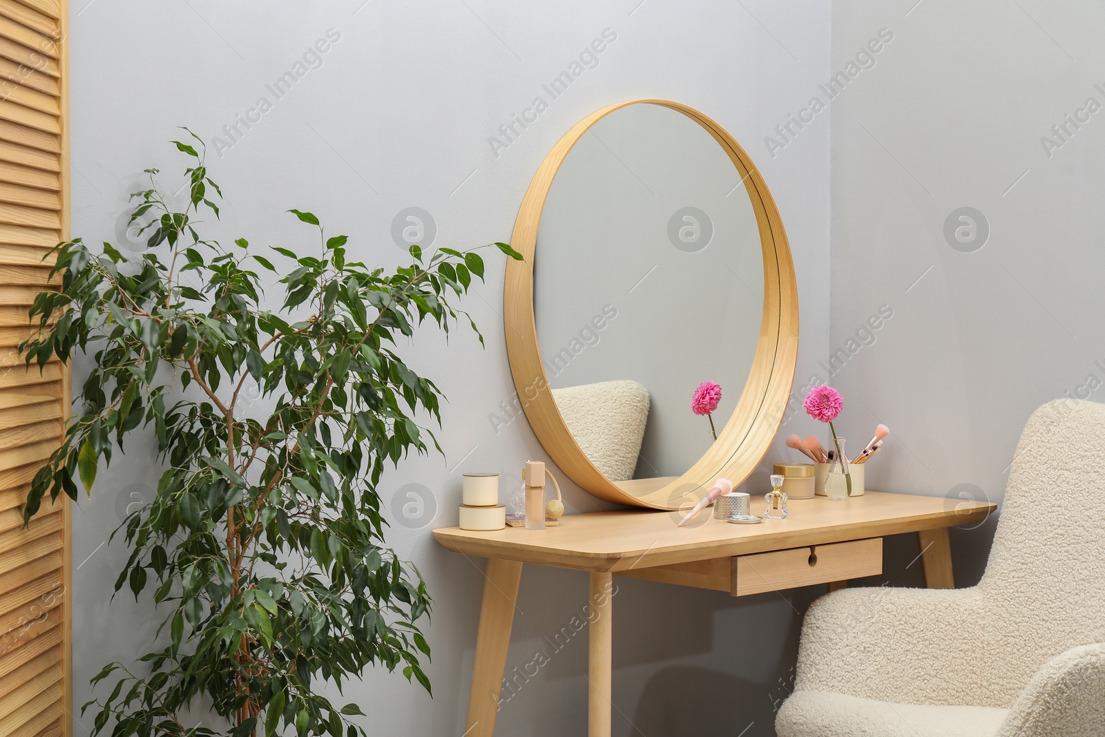 Photo of Mirror, dressing table, houseplant and armchair indoors. Interior design