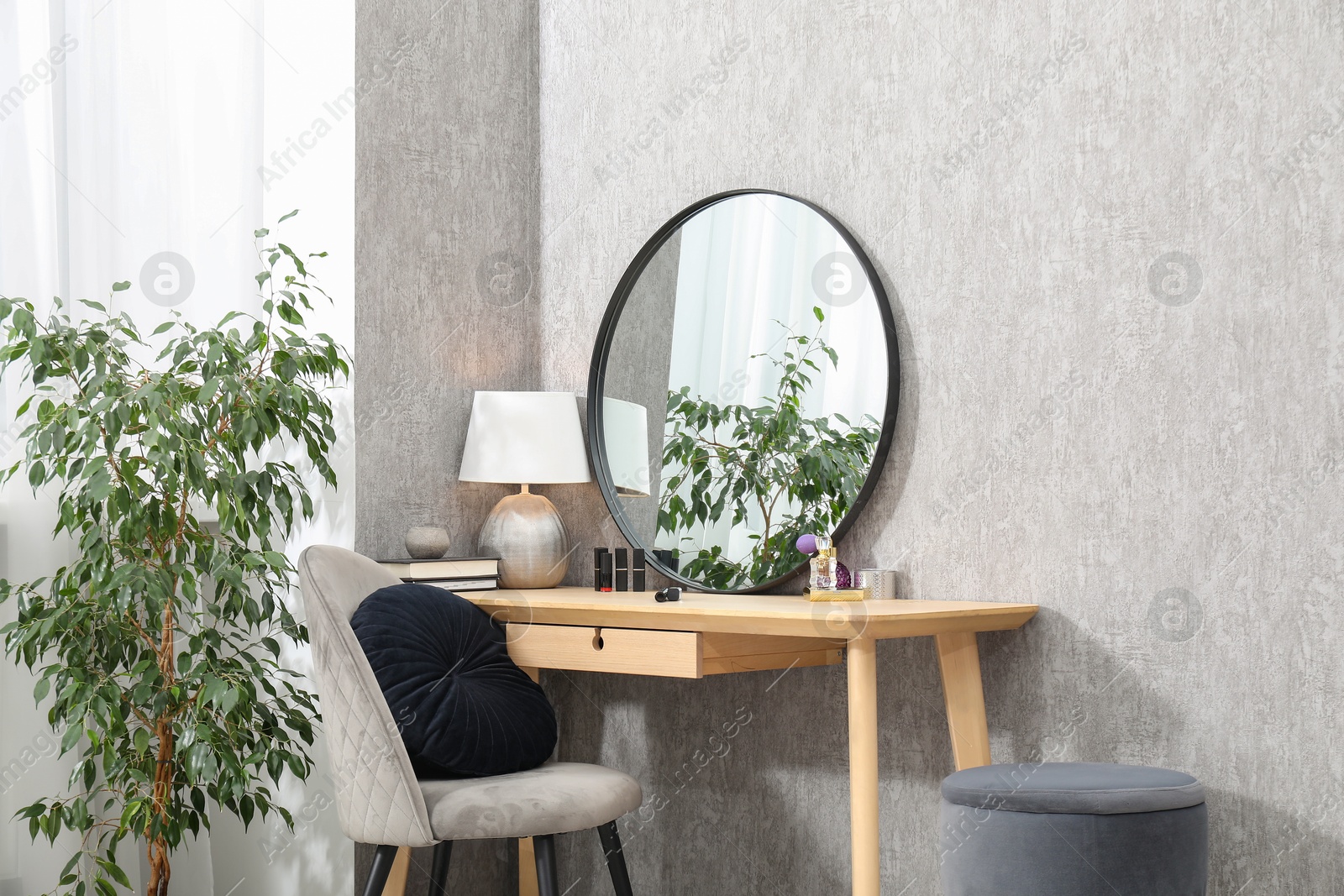 Photo of Mirror, dressing table, lamp, chair and houseplant indoors. Interior design