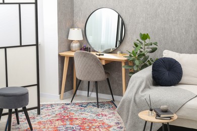 Mirror, dressing table, chairs and folding screen indoors. Interior design