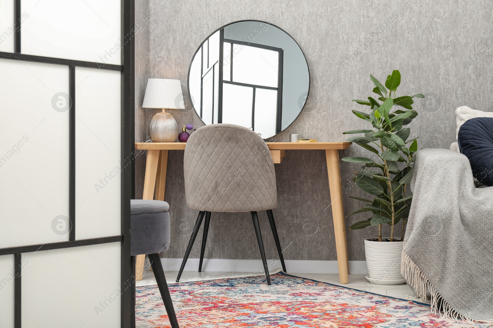 Photo of Mirror, dressing table, chair, houseplant and folding screen indoors. Interior design