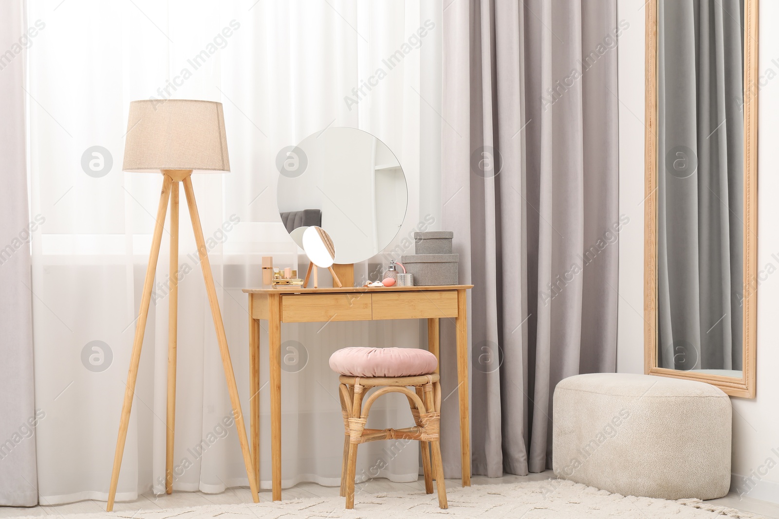 Photo of Mirrors, dressing table, lamp and stool near window indoors. Interior design