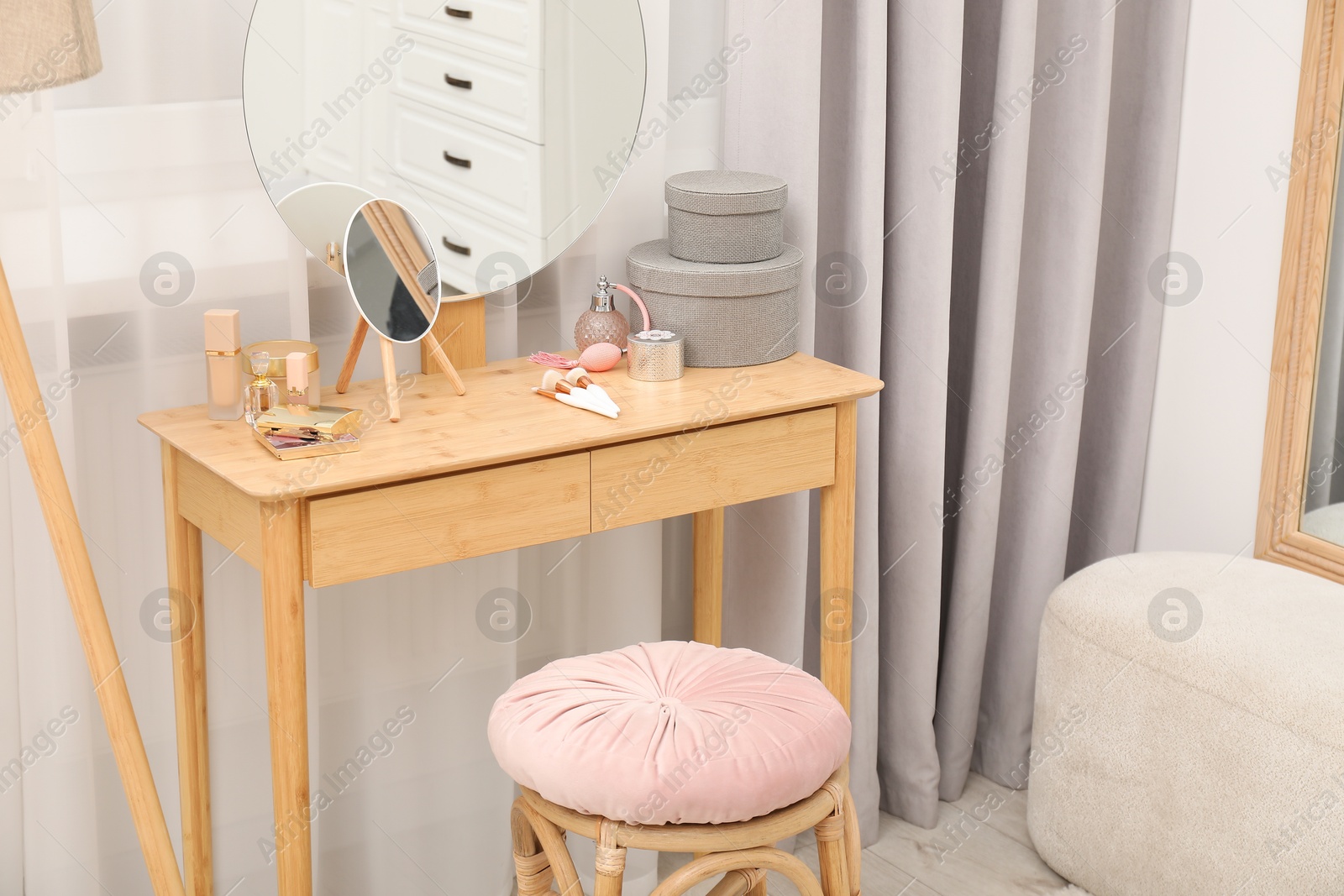 Photo of Mirror, dressing table, lamp and stool near window indoors. Interior design