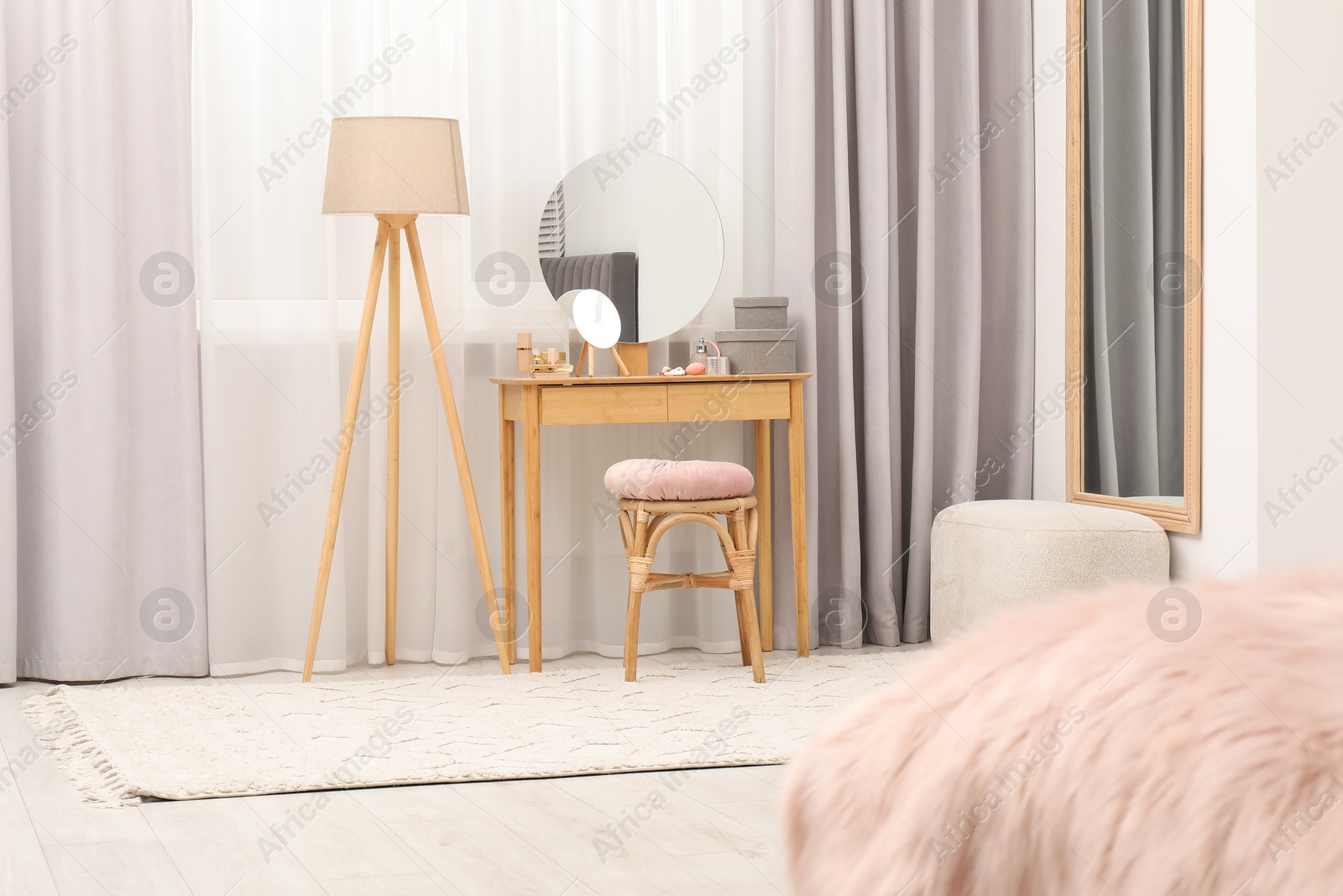 Photo of Mirrors, dressing table, lamp and stool near window indoors. Interior design