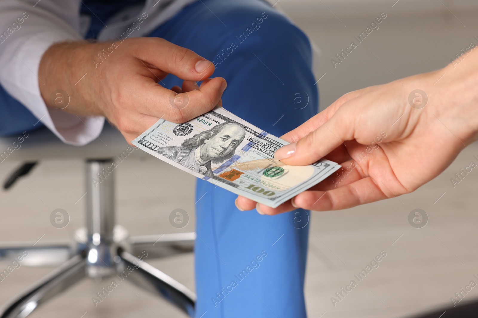 Photo of Corruption concept. Woman giving dollar banknotes to man under table, closeup