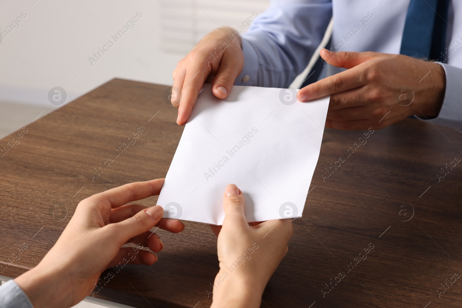 Photo of Corruption concept. Woman giving envelope with money to man at wooden table, closeup