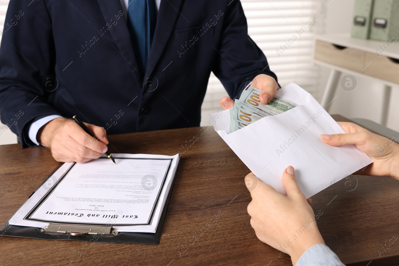 Photo of Corruption concept. Woman giving envelope with money to man at wooden table, closeup