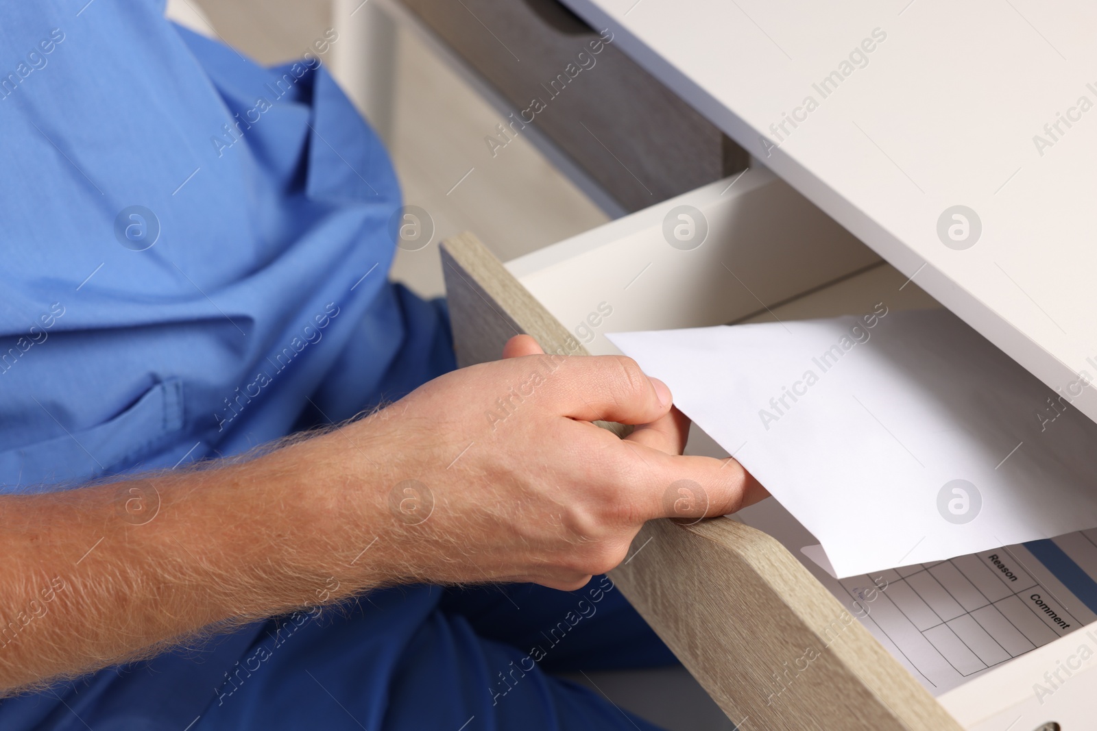 Photo of Corruption concept. Doctor putting envelope with money into drawer, closeup