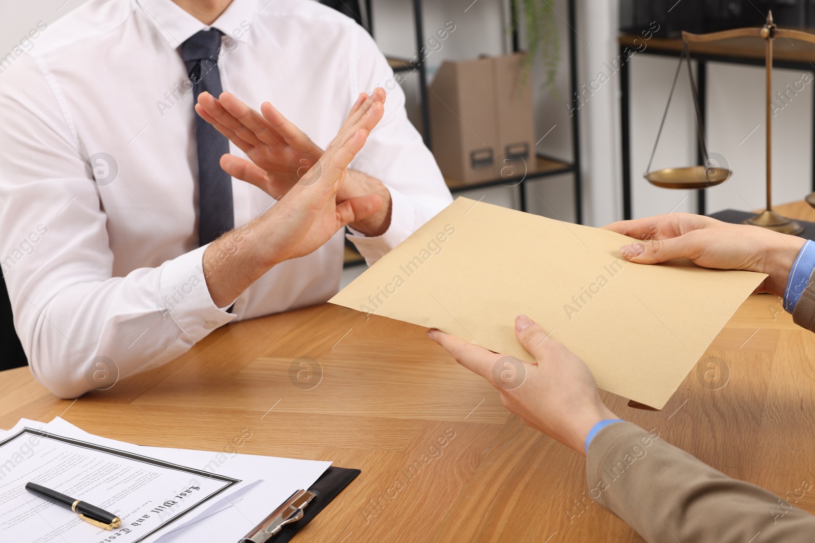 Photo of Corruption concept. Woman giving envelope with money to man at wooden table, closeup