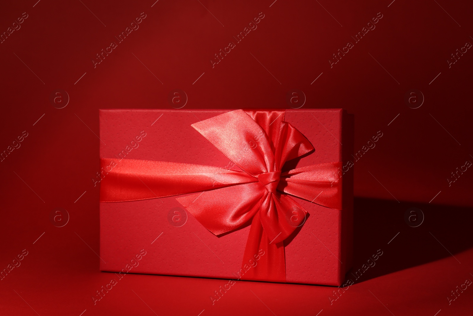 Photo of Red gift box on dark red background