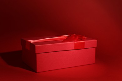 Photo of Red gift box on dark red background