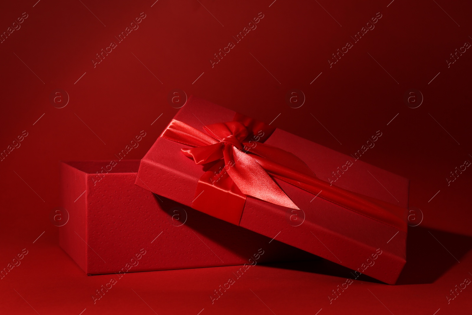 Photo of Red gift box on dark red background