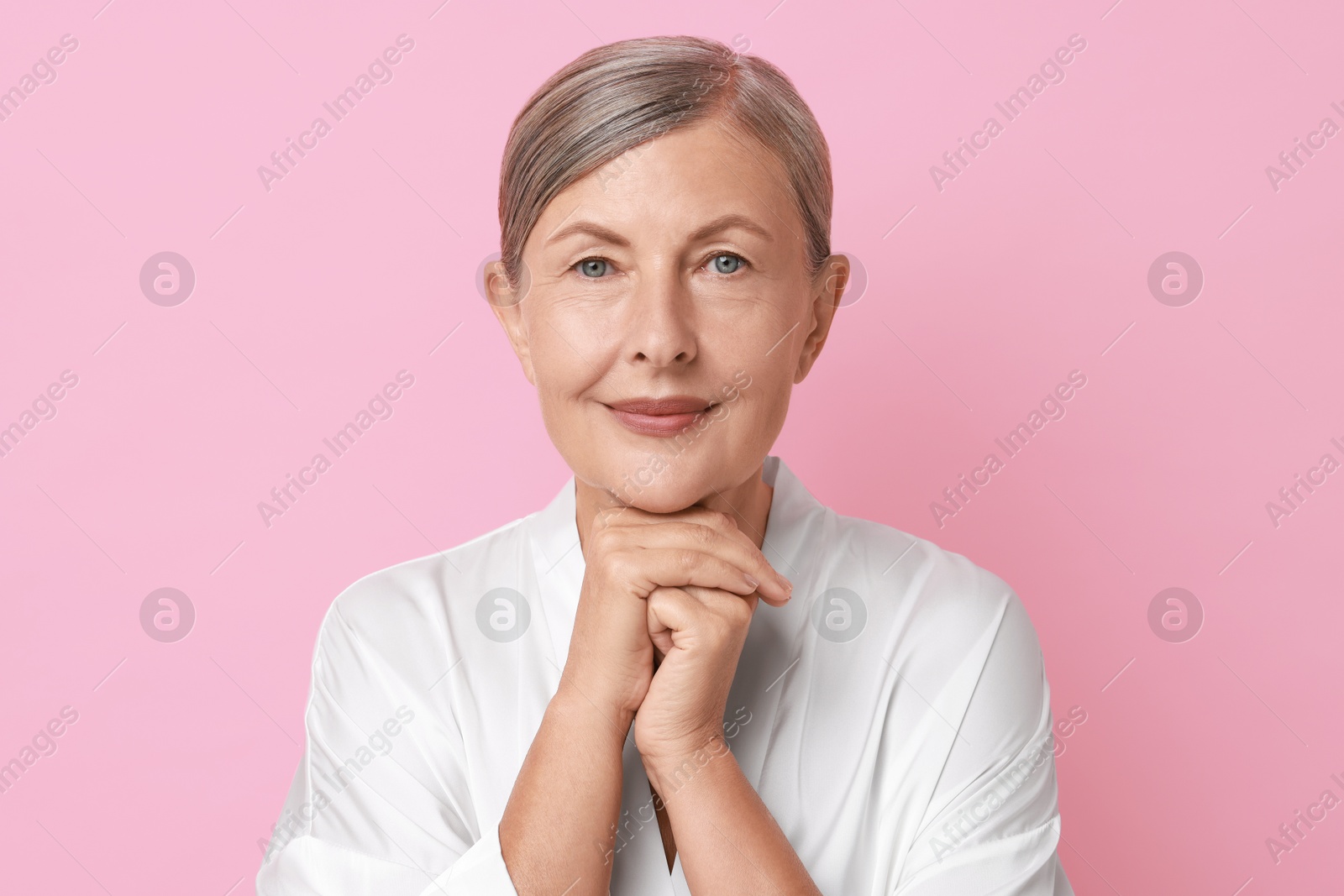 Photo of Face massage. Beautiful woman with healthy skin on pink background