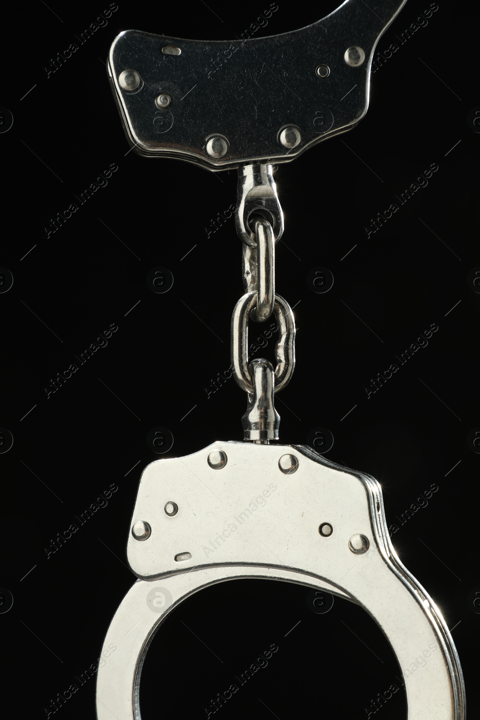 Photo of Metal chain handcuffs on black background, closeup